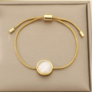 Détail du bracelet chaîne serpent dorée ajustable avec pierre œil de chat blanche
