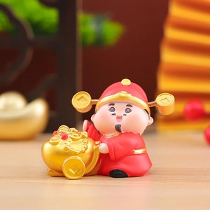 Macro shot of cute God of Wealth figurine with gold ingot cart for Chinese New Year