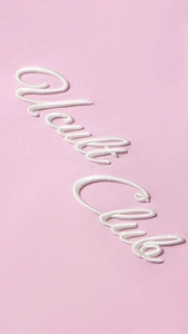 Detailopname van het witte Health Club borduursel op roze katoenen T-shirt