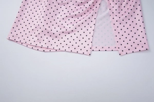 Detail of pink polka dot bikini skirt featuring a side slit and precise stitching design