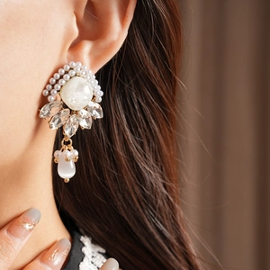 Dettaglio dell'orecchino vintage in stile palazzo con diamanti e perle indossato