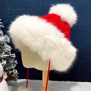 Festive red knit Christmas trapper hat with white faux fur trim and pom-poms on a stand