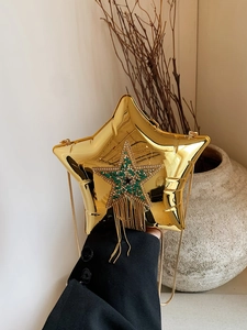 Detail of star-shaped gold evening bag with rhinestone tassels and beaded patterns