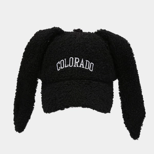 Close-up of white COLORADO embroidery on a black teddy fleece bunny ear baseball cap