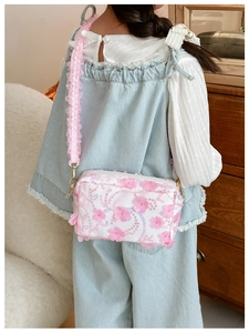 Detail of floral crossbody bag featuring 3D flowers, sequins and pink ruffled lace strap