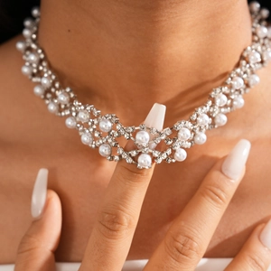 Close-up of double-layered silver flower necklace with faux pearls and rhinestones on neck