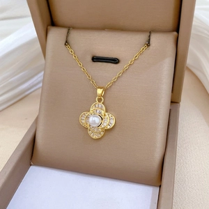 Detail of gold floral necklace featuring a white pearl and sparkling zircon accents