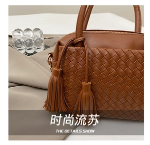 Close-up of caramel leather crossbody bag with cross-woven texture and tassels