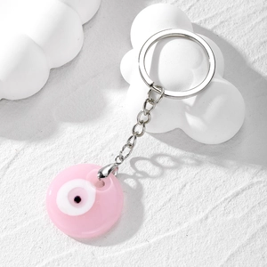 Detailed macro view of a pink resin evil eye keychain with silver metal clip ring
