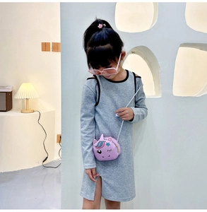 Detail of girl wearing a grey off-shoulder dress with a purple unicorn crossbody bag
