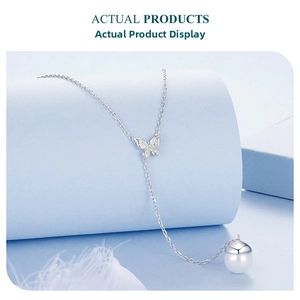 Detailed macro view of S925 silver butterfly necklace with white pearl and acorn pendant