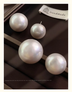 Macro shot of oversized pearl earrings showing fine luster and S925 silver pins