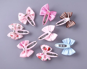 Detail shot of multi-patterned bow hair clips with stripes and fruit prints for girls