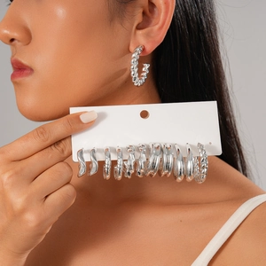 Close-up of 12-piece silver geometric earring set showing textured and smooth hoop details