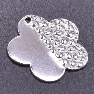 Detailed view of silver clover pendant featuring unique hammered and smooth metal textures