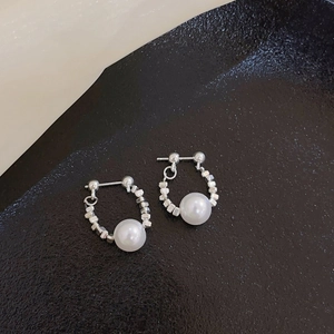 Silver needle hoop earrings with crushed silver beads and white pearls on black texture