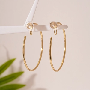 Detail of gold circular clip-on earrings with mosquito coil back and soft silicone pads