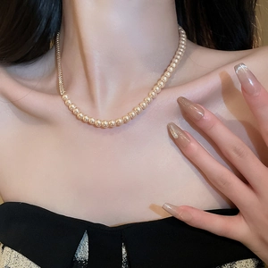 Elegant gold-plated necklace with spliced pearls and zircons worn by a female model