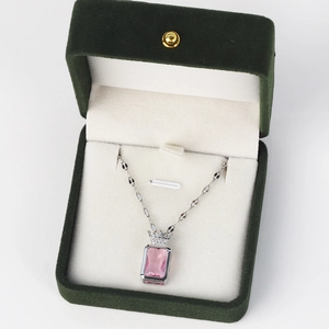 Detail of pink square gemstone necklace with crown motif in green velvet box