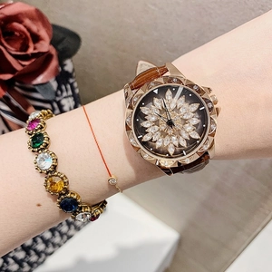 Elegant woman wearing rose gold watch with brown leather strap and rhinestone flower dial