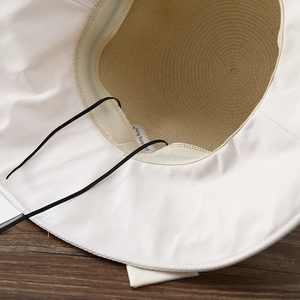 Detail of breathable straw sun hat interior with windproof rope and wide brim
