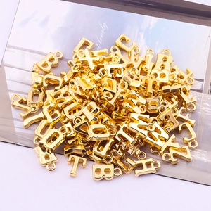 Detailed macro view of assorted golden alloy alphabet pendants for DIY jewelry making