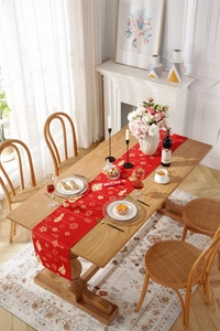 Close-up of red festive table runner with golden clouds, lanterns and tassel details