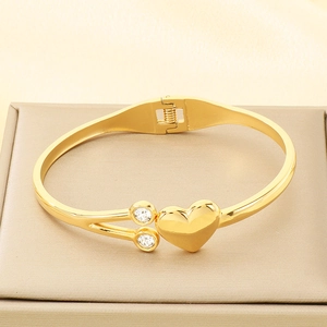 Detailed macro view of a gold heart-shaped bangle with sparkling rhinestone accents