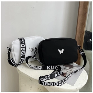 Macro shot of nylon crossbody bags with butterfly buckle and printed wide shoulder straps