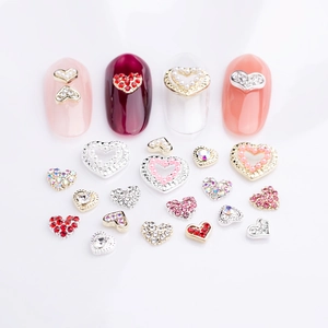 3D Heart Nail Art Charms with rhinestones and pearls on white background