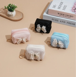 Four mini corduroy coin purses in pink, black, blue and beige with lace bows and keychains