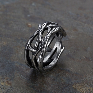 Detail of vintage silver thorn branch ring with polished finish on dark stone background