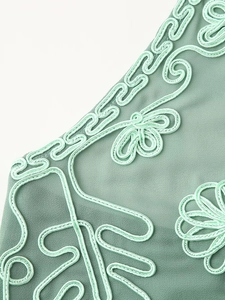 Détails de la broderie verte complexe sur le tissu d'une robe de style bohème avec macro focus
