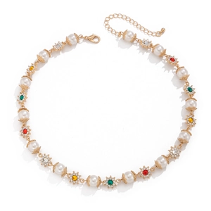Détail de fleurs dorées avec strass multicolores et perles blanches sur collier chic