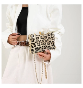 Detailed close-up of leopard print evening clutch featuring gold metal frame and diamond clasp