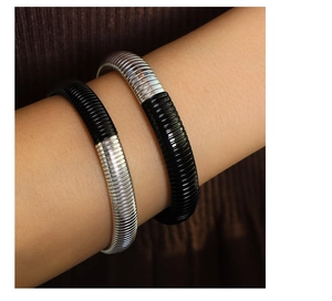 Detail of Tubogas style stretch bracelets featuring silver and black textured steel coils