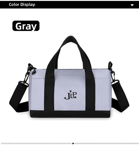 Detailed view of gray nylon crossbody bag with black handles and adjustable shoulder strap