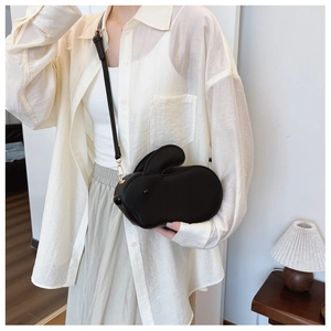 Vue détaillée d'un sac à bandoulière en forme de lapin noir porté par un mannequin