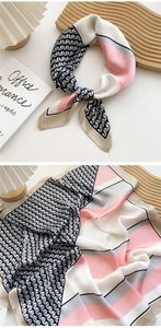 Detail of elegant silk scarf with geometric triangle patterns on wooden tray display