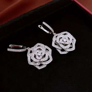 Macro detail of silver rose earrings with cubic zirconia pavé in a black velvet box