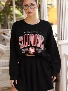Dettaglio della stampa California rossa e bianca su felpa girocollo nera in stile oversize