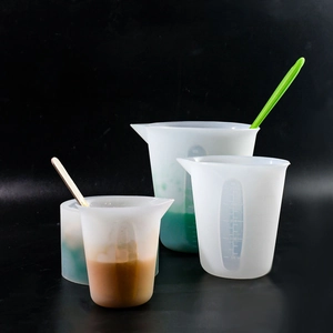 Detail of translucent silicone measuring cups with clear scale marks and stirring sticks