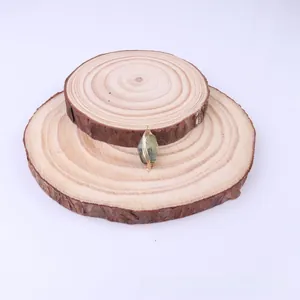 Detailed view of wire-wrapped natural green stone pendant on a rustic wooden stand