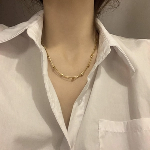 Detail of minimalist double-layered golden square pendant necklace on model