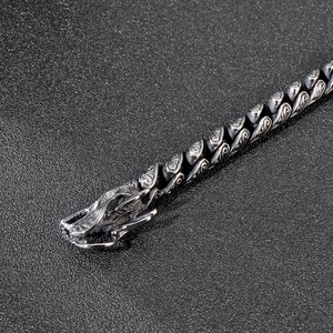 Macro detail of vintage double dragon head link bracelet in polished stainless steel