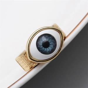 Detailed view of gold plated evil eye ring with blue iris and textured metal finish