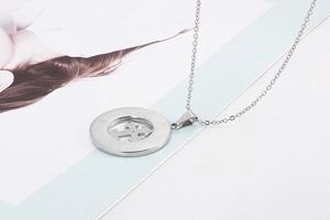 Detailed close-up of a silver titanium steel necklace with a hollow cross round pendant