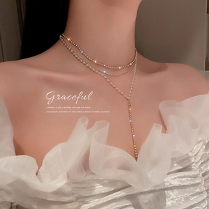 Elegant multi-layer gold necklace with pearls and sparkling diamond-studded Y-shaped tassels