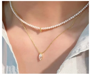 Close-up of double-layer necklace with white pearls and marquise cut zircon pendant