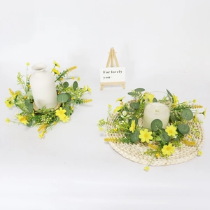 Floral candle ring with yellow daisies and eucalyptus leaves for table decoration
